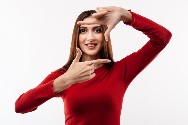 有趣的女人微笑的照片，用手指做相框。人的情绪、表情概念图片下载