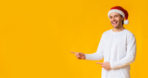 一个戴着圣诞帽的快乐的千禧一代，表示有空的地方图片下载