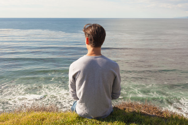 一个平静的年轻人在海滩享受一个安静的自我时光。图片下载