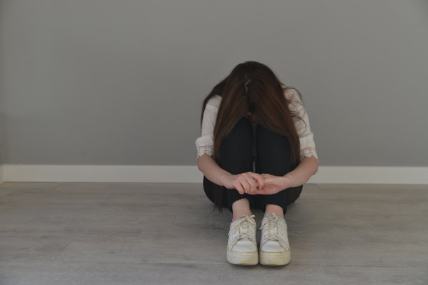 年轻的女孩垂着头坐在地上图片下载