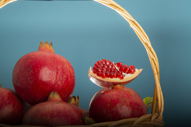 柳条篮子里有多个红石榴。在摄影棚进行微距拍摄。高质量和高分辨率。图片下载