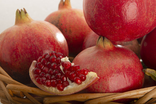 柳条筐里的多个红色石榴。工作室微距拍摄。高品质和高分辨率。图片下载