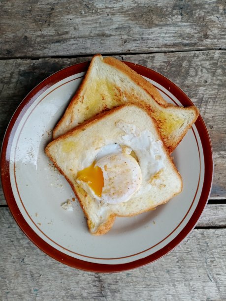 早餐有两片吐司和融化的半熟鸡蛋图片下载