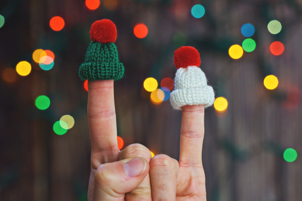 手指摇滚山羊在编织帽子在五颜六色的圣诞节背景图片下载