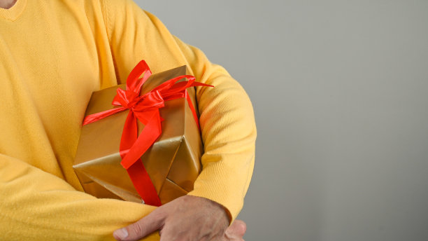 穿黄色毛衣的男人包装礼物图片下载