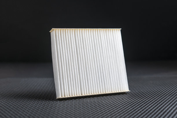一个新的方形白色汽车空气滤清器平铺在暗色背景上图片下载