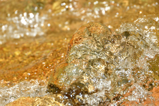 金橙色自流井从地面涌出，近距离的抽象图片下载