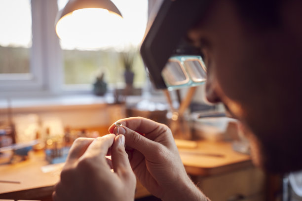 男性珠宝商看戒指通过头带放大镜在工作室的特写图片下载