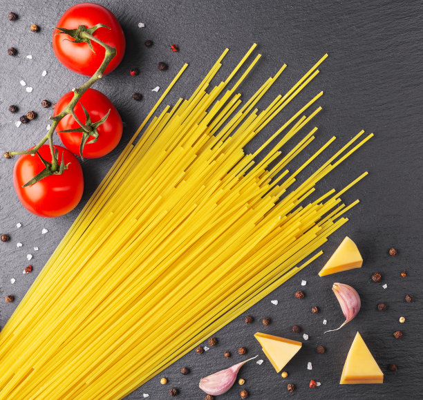 桌上放着意大利面，红番茄，大蒜和香草图片下载