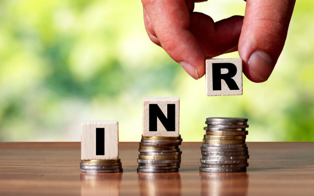 印度货币字符号-商业概念。手放木块上堆叠增加硬币图片下载