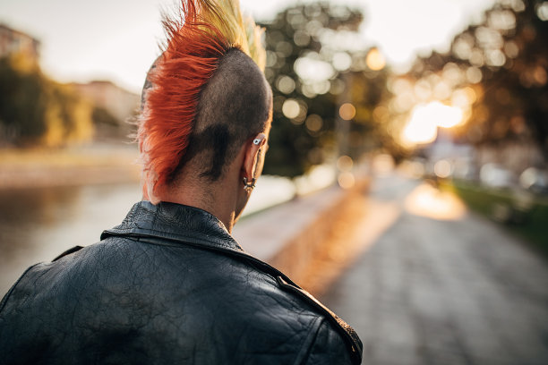 染着莫霍克头的朋克男站在城市的街道上图片下载