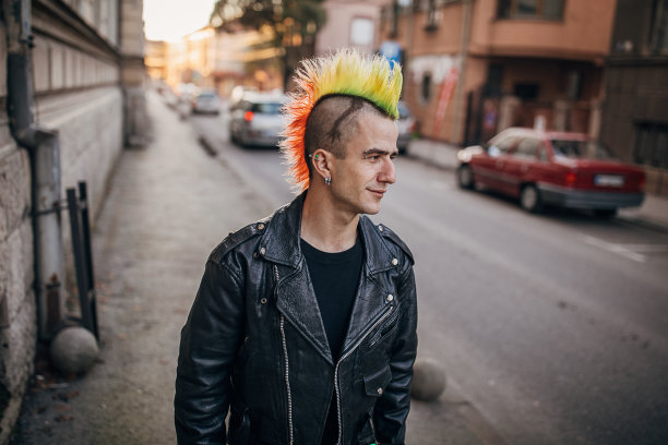 一个留着五颜六色发型的小丑走在街上图片下载