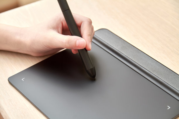 女孩用钢笔在绘图板上画画。特写,有选择性的重点图片下载