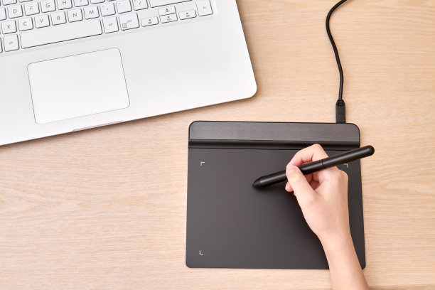 女孩用钢笔在绘图板上画画。特写,有选择性的重点。图片下载