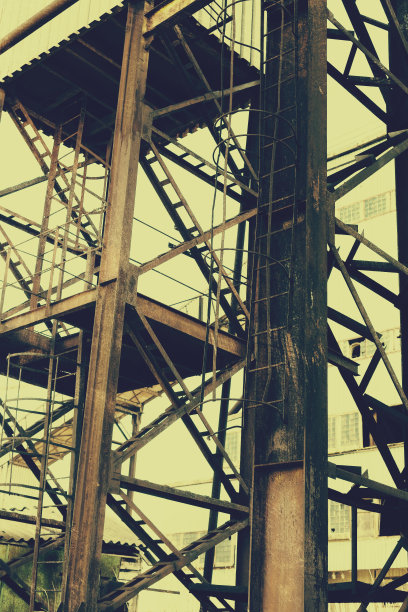 旧的，生锈的门式起重机在铁路上，一个废弃的混凝土工厂。危机、经济崩溃和生产能力的关闭导致了崩溃。全球灾难。一张古老照片的效果。图片下载