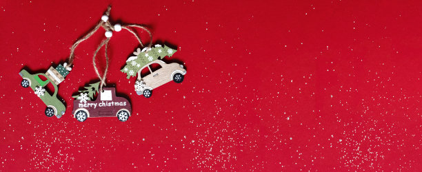 圣诞和新年的节日树汽车木制玩具组成在红色的背景，圣诞心情，俯视图，复制空间，雪。图片下载