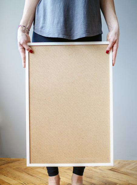 年轻女子手持白色镜框，空白广告牌图片下载