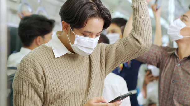 旅客在公共列车上戴口罩使用手机图片下载