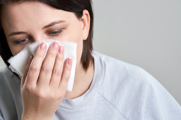 年轻妇女手持纱布或绷带，而不是医用口罩来保护自己免受冠状病毒感染。口罩概念不足图片下载