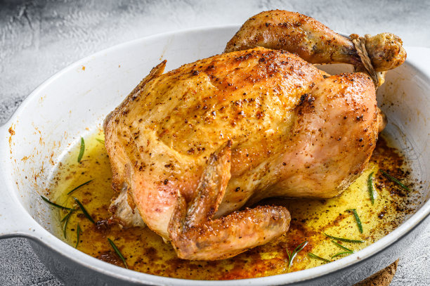 美味的烤鸡，酥脆的瓷盘。白色背景。俯视图图片下载