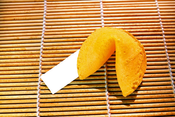 一张以竹席为背景的幸运饼干的照片。纸张标签显示，没有文本，并留下复制空间的消息。图片下载