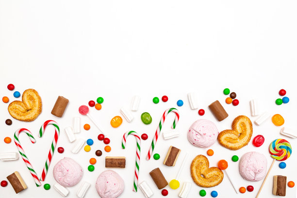 各种颜色的糖果在白色的背景。棒棒糖，焦糖，拐杖糖，棉花糖，巧克力，饼干俯视图图片下载