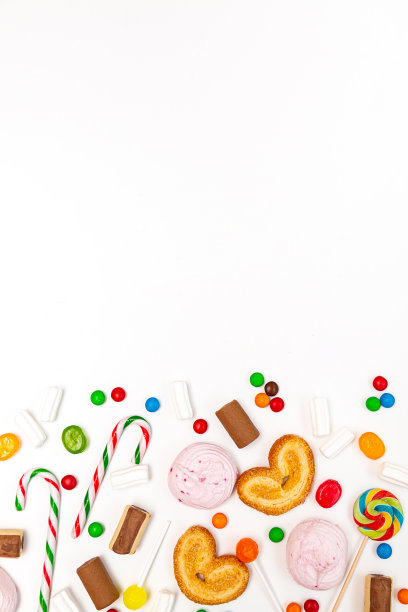 各种颜色的糖果在白色的背景。棒棒糖，焦糖，拐杖糖，棉花糖，巧克力，饼干俯视图图片下载