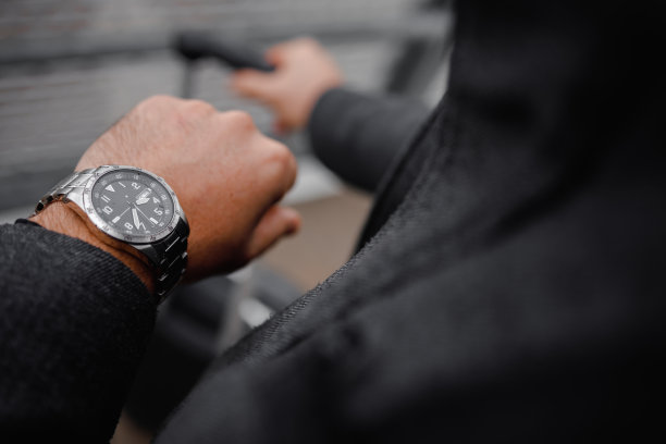 一个面目全非的男人在看他的手表。图片下载