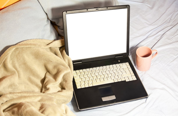 笔记本电脑，舒适的毯子，枕头和一杯茶躺在未整理的床上，在家里工作，家庭娱乐和放松时刻，放松抽象的概念图片下载