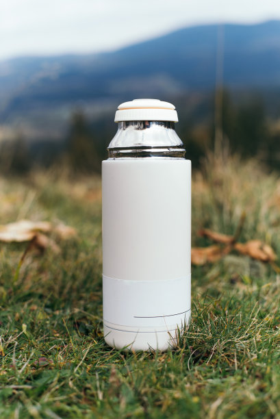 徒步旅行的静物生活与一个现代的热杯上的一座山，以喀尔巴阡山脉景观的背景在乌克兰。奇妙的探险之旅的背景。便携式保温瓶图片下载