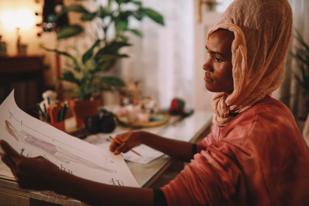 女设计师穿着扎染衬衫在她的客厅工作图片下载