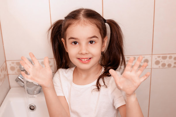 梳着马尾辫的黑发小妞，站在浴室里，露出泡沫手掌，微笑着，看着镜头图片下载