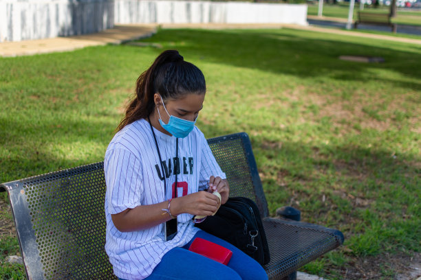 在大学里用水酒精凝胶消毒手的女孩图片下载