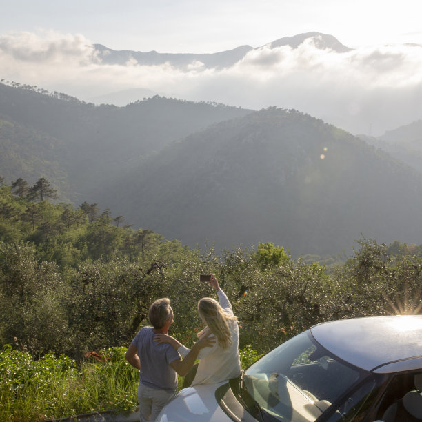 成熟的夫妇在日出时在车外放松图片下载