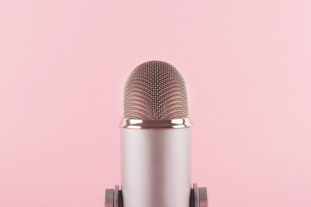一个粉红色背景装饰的麦克风。最小的原料油。图片下载