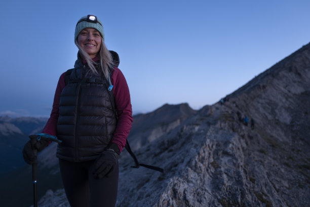 女人在日出时沿着山脊徒步图片下载