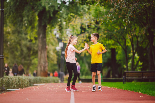 青春期前活跃的娱乐和运动儿童。10岁的白种双胞胎男孩和女孩在穿过公园的红色橡胶跑道上慢跑。孩子们的弟弟和妹妹在户外跑步机上跑步图片下载