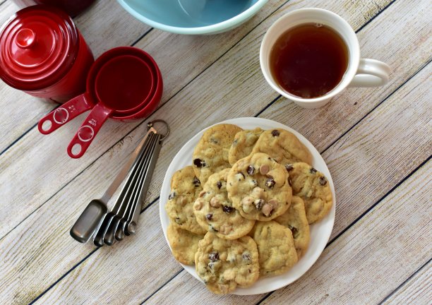 新鲜自制的热巧克力饼干与搅拌碗，测量勺子，作为一种甜蜜的零食在寒冷的冬天享受图片下载