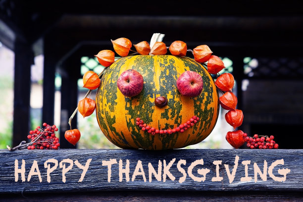 感恩节快乐-文字与装饰南瓜的木制表面-秋天的象征。秋高气爽，丰收丰收，万圣节狂欢。图片下载