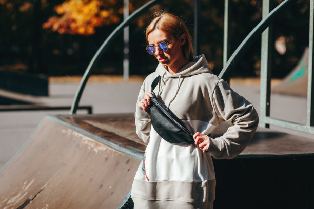 时尚的模特女孩在滑板公园在眼镜与腰袋图片下载