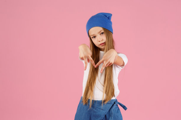 一个7岁的小女孩，穿着一件白色的衬衫，在粉红色的背景下，快乐和幸福的情绪。本空间图片下载