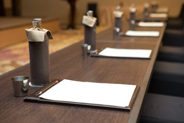 纸张、铅笔、水瓶、玻璃杯放在会议室背景的桌子上图片下载