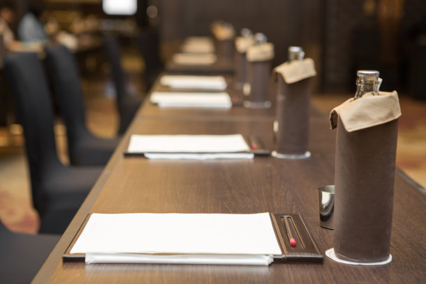 纸张、铅笔、水瓶、玻璃杯放在会议室背景的桌子上图片下载