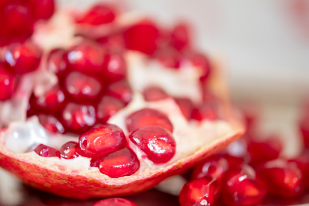 木桌上鲜亮多汁的石榴特写图片下载