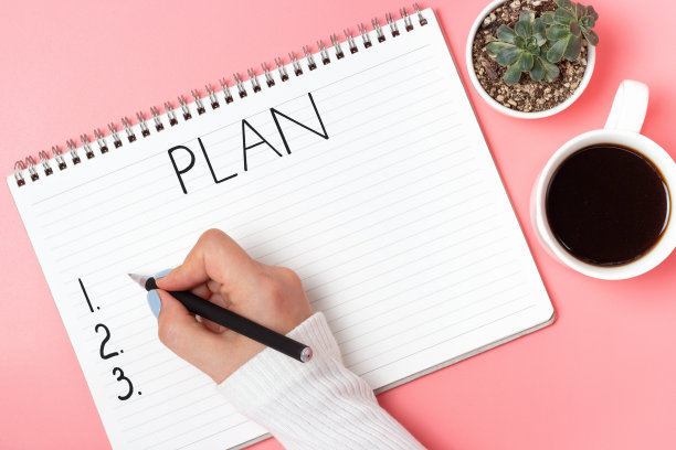 女人的手写在粉红色背景的记事本上图片下载