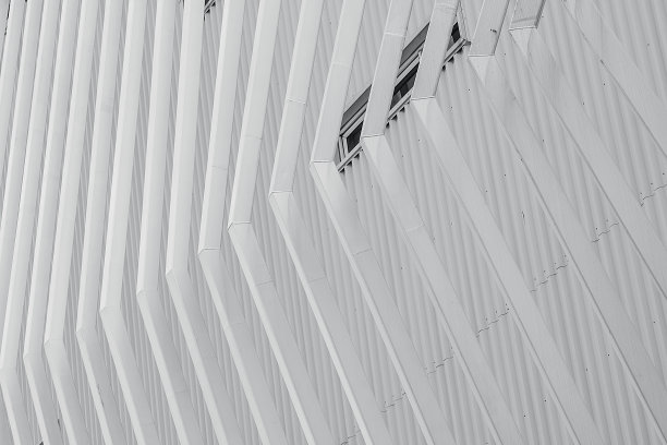 白色立面建筑抽象背景。现代的未来主义建筑。钢包层波纹金属板建筑立面。建筑外墙结构。门面模式设计。图片下载