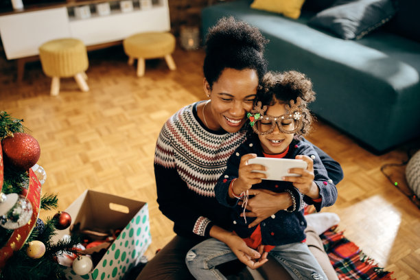 快乐的非裔美国母亲和女儿在圣诞节自拍。图片下载