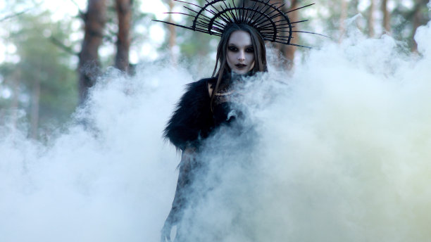女巫形象中的女人在森林中穿过烟雾。图片下载