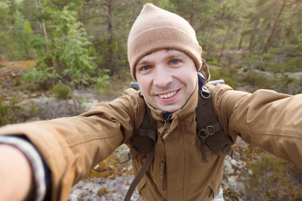 年轻的白人男子在森林里自拍。图片下载