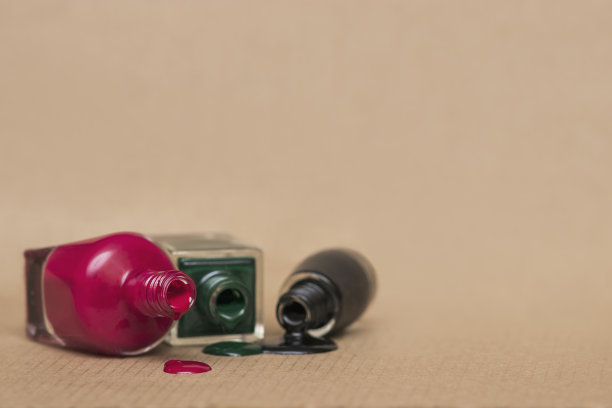 三瓶倒置的红，黑，绿指甲油。图片下载